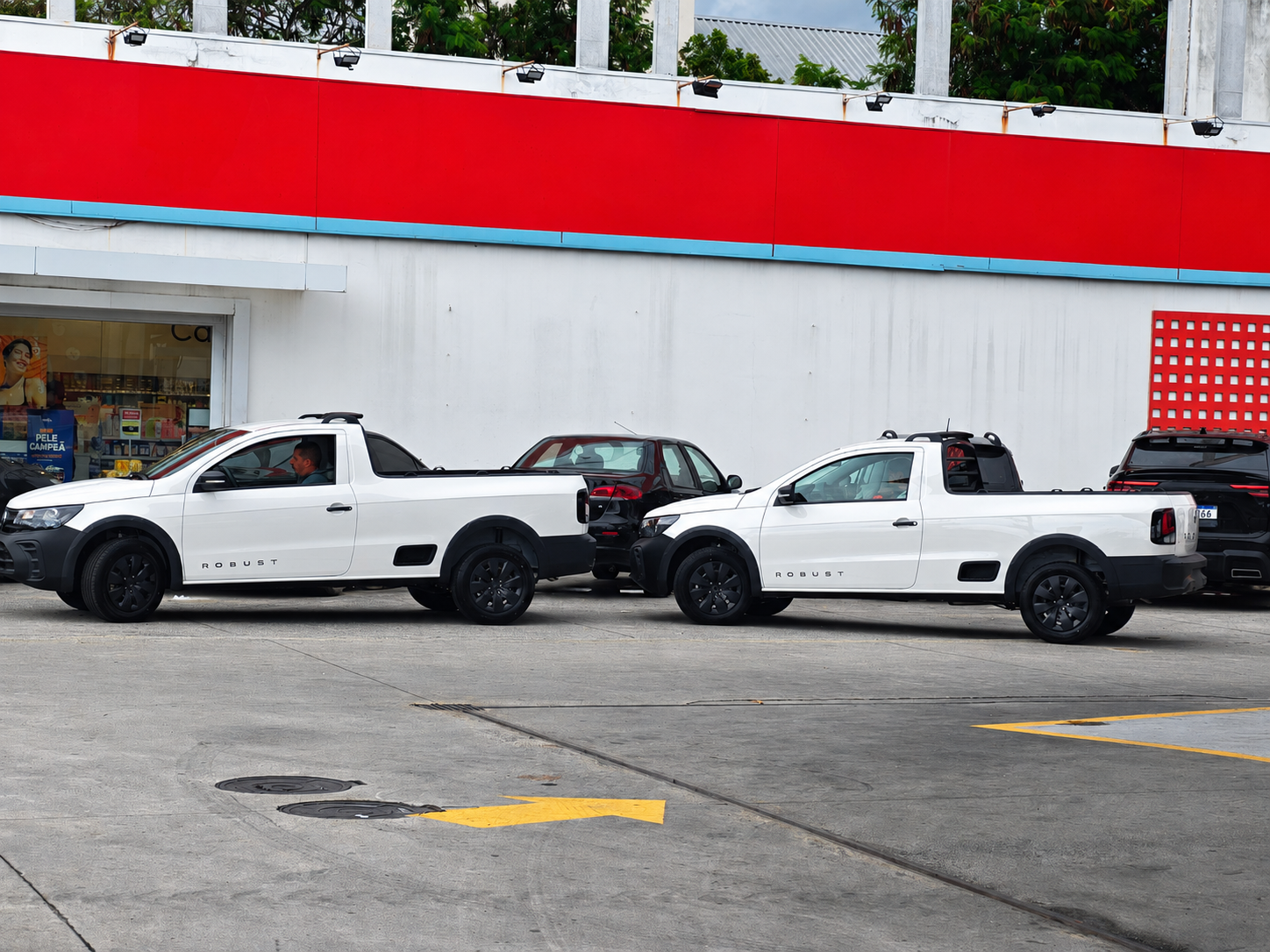 Duas picapes brancas da Mova-Se Soluções estacionadas em vista lateral